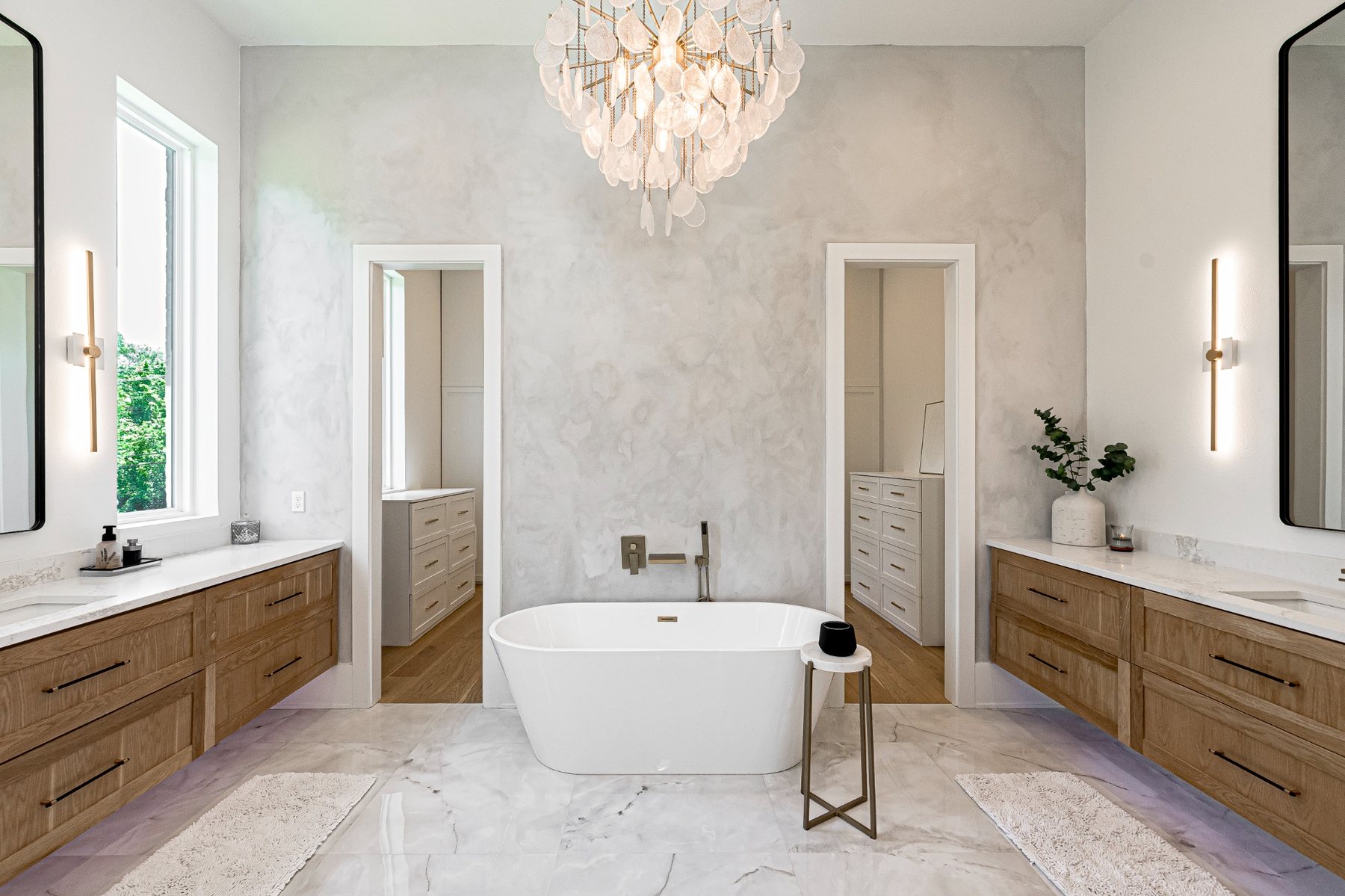 Primary bath with plaster wall and chandelier